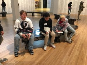 Students in an art gallery looking, thinking, writing.